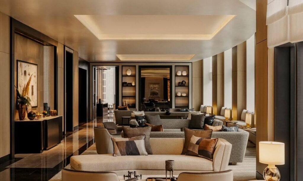 Artist’s rendering of an elegant residential lounge with layered sofas, warm lighting, polished floors, and contemporary décor