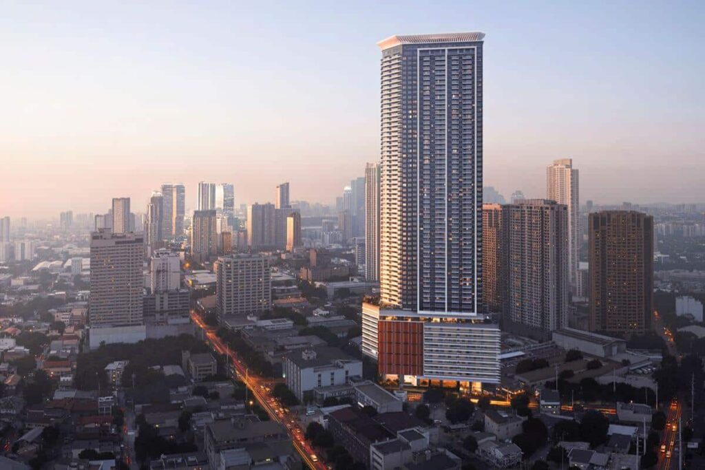 High-rise Shang Properties residential tower rising above a well-connected Metro Manila urban district at sunset