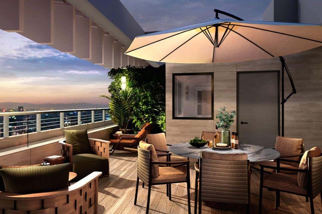Luxury condominium balcony with outdoor seating overlooking the city skyline at sunset