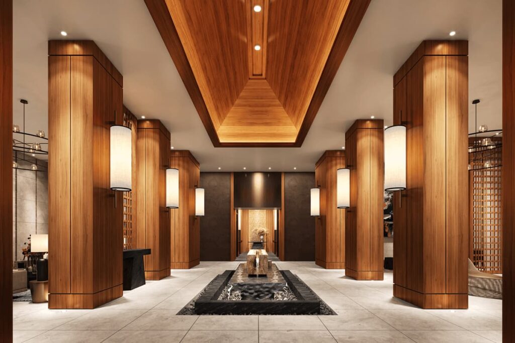 Grand luxury condominium lobby with warm wood finishes, dramatic lighting, and refined architectural details