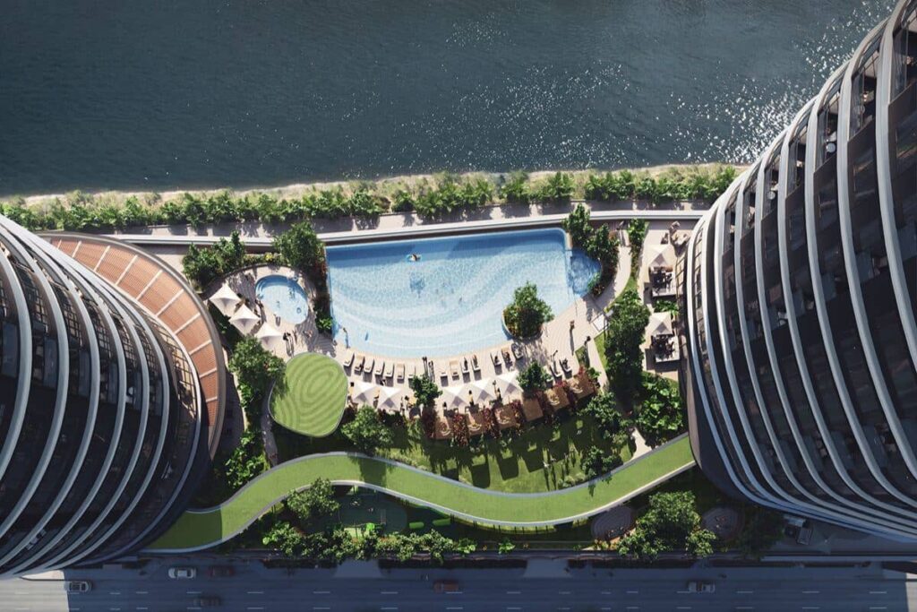 Aerial view of luxury residential towers surrounding a landscaped swimming pool and green amenity spaces